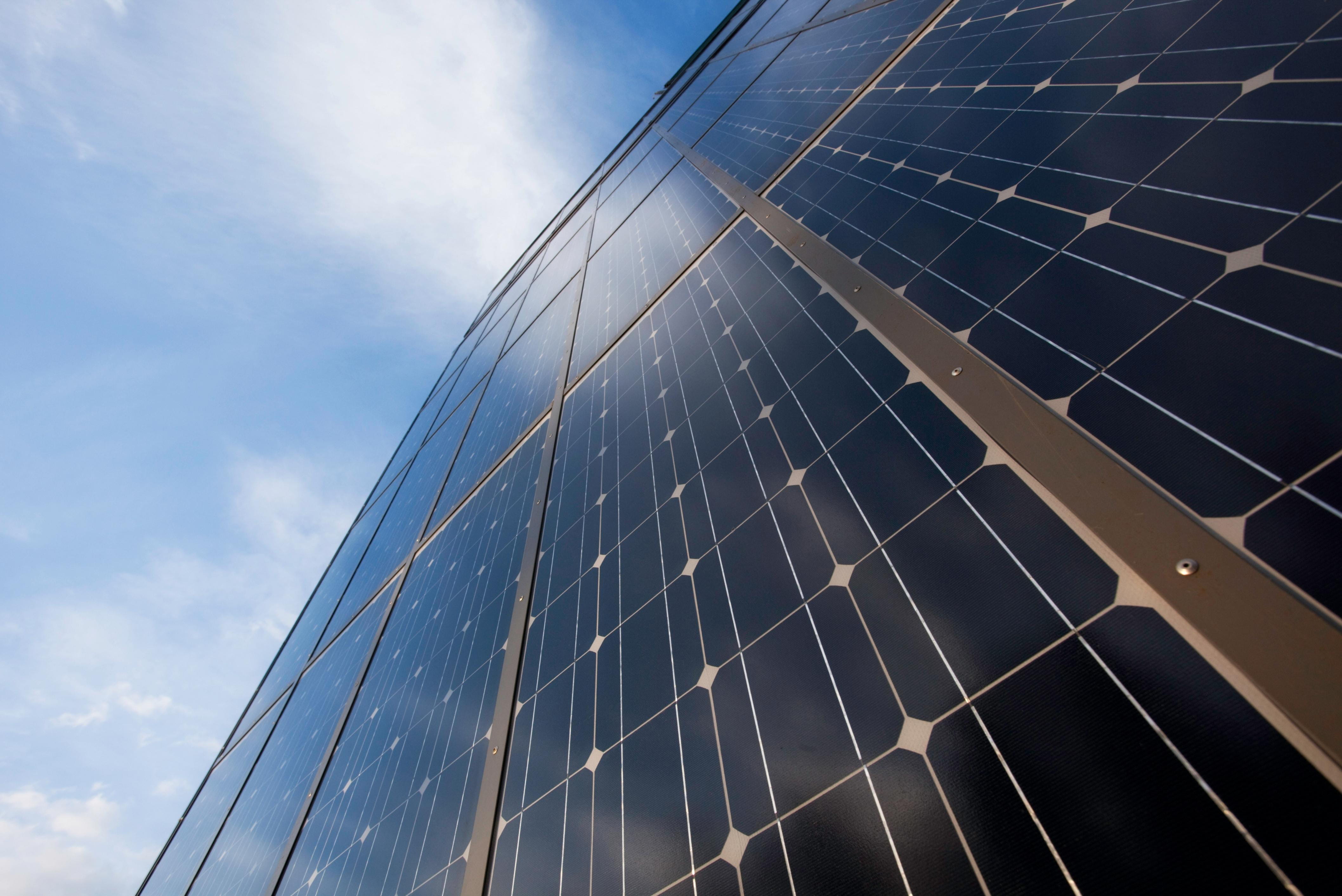 Grid-tied solar panels under a blue sky
